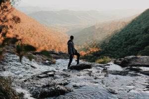 man standing in a creek-unsplash