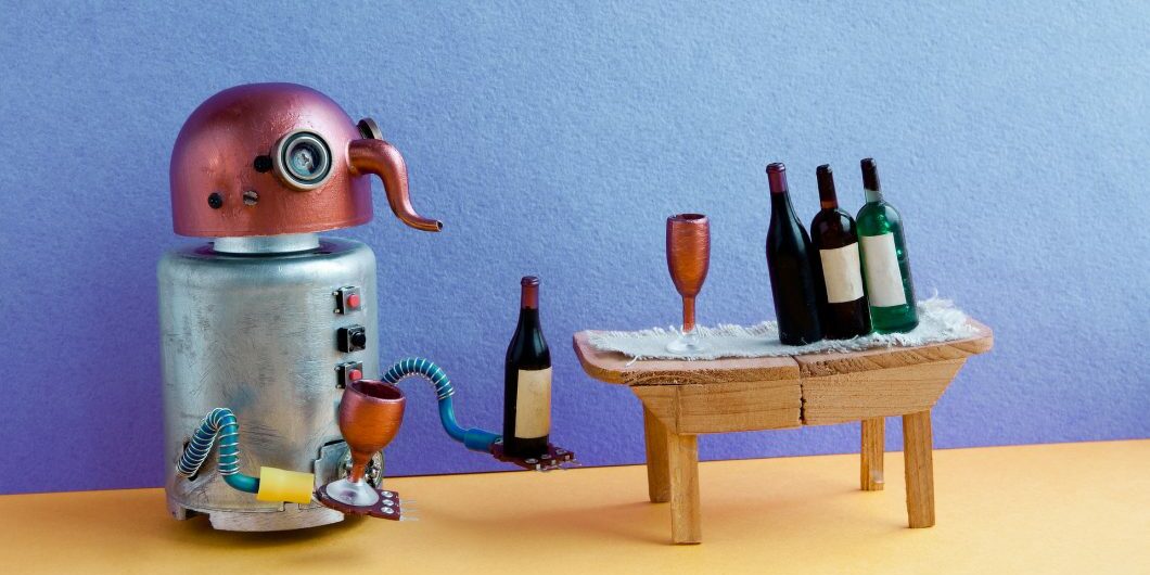 Wine bar party event concept. Funny robot alcoholic drink wine. Creative design copper head cyborg toy gets drunk. Wooden table, bottles, blue yellow room interior